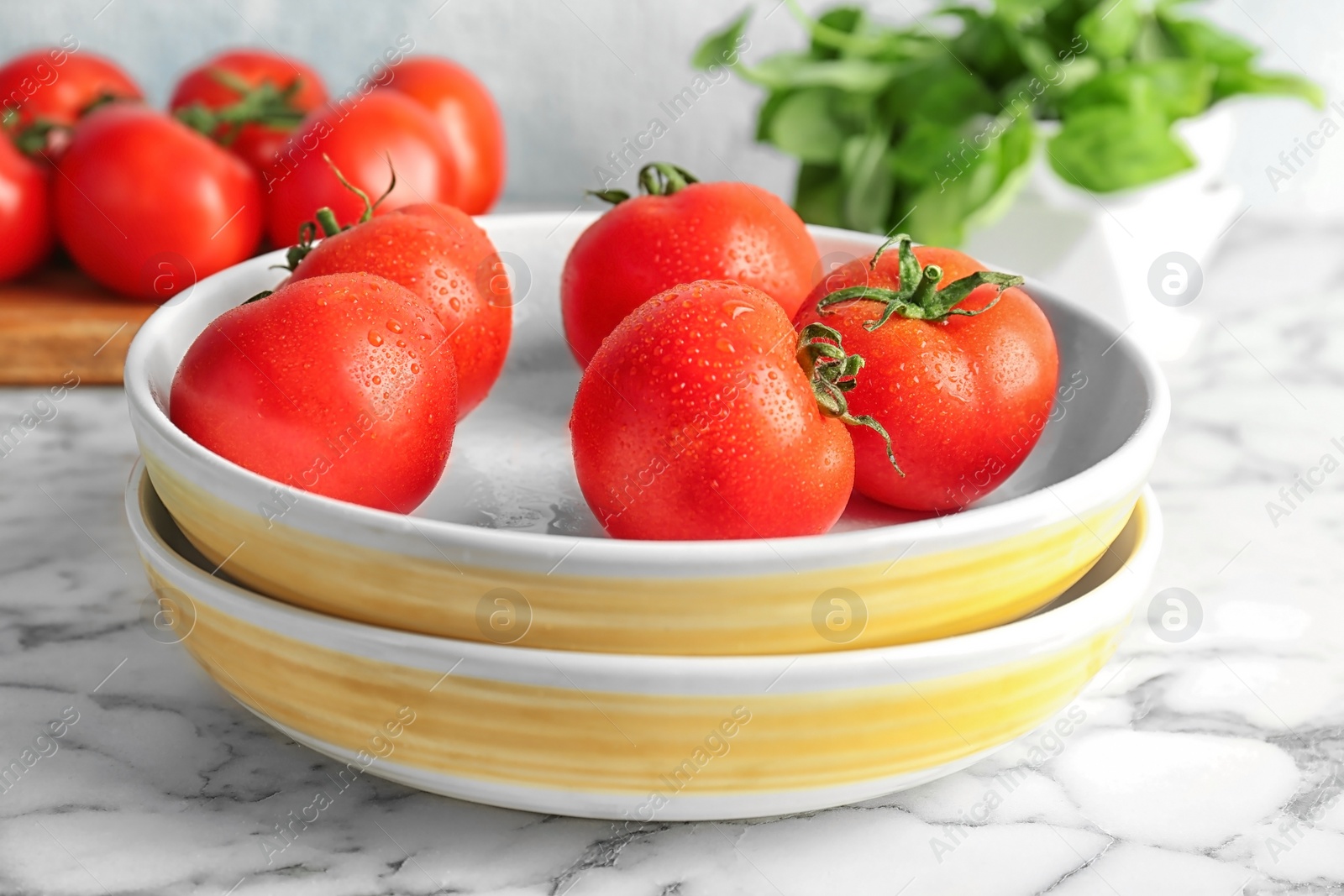 Photo of Plates with fresh ripe tomatoes on table