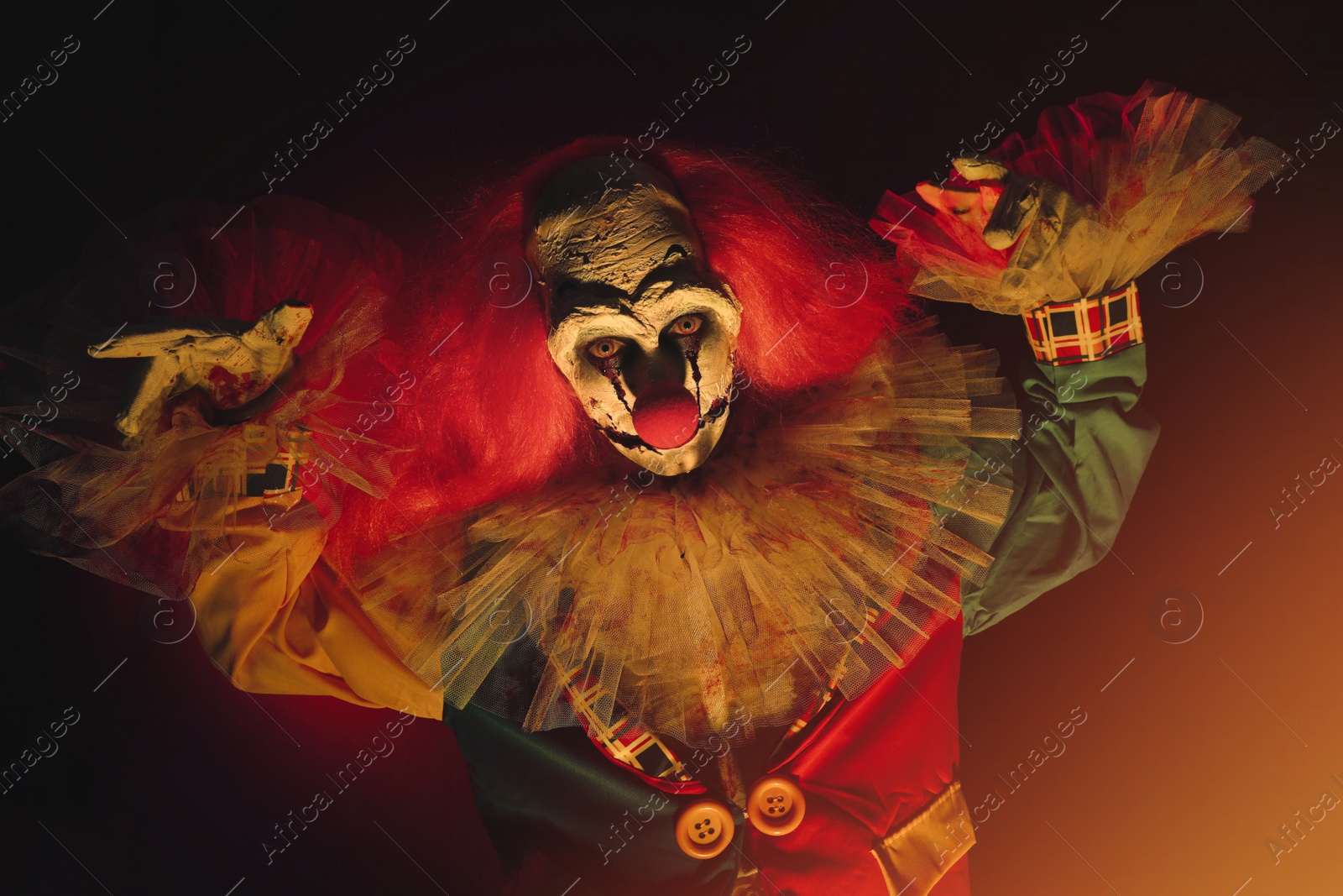 Photo of Terrifying clown in darkness. Halloween party costume