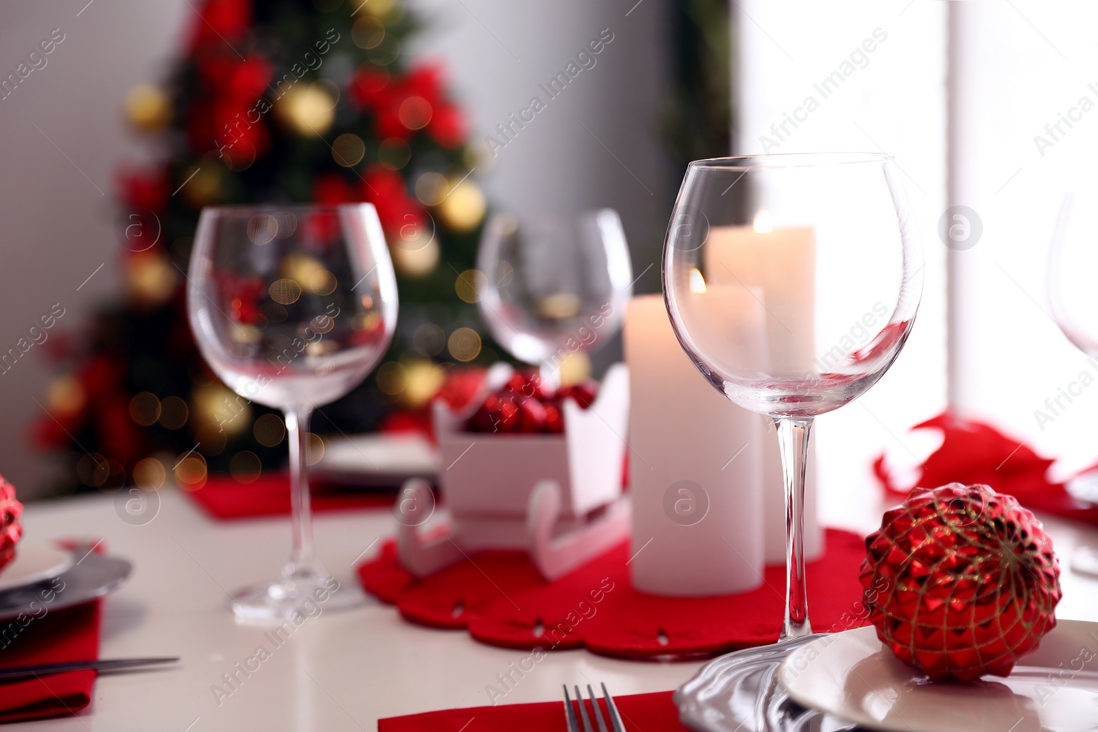 Photo of Festive table setting and Christmas tree in stylish room interior