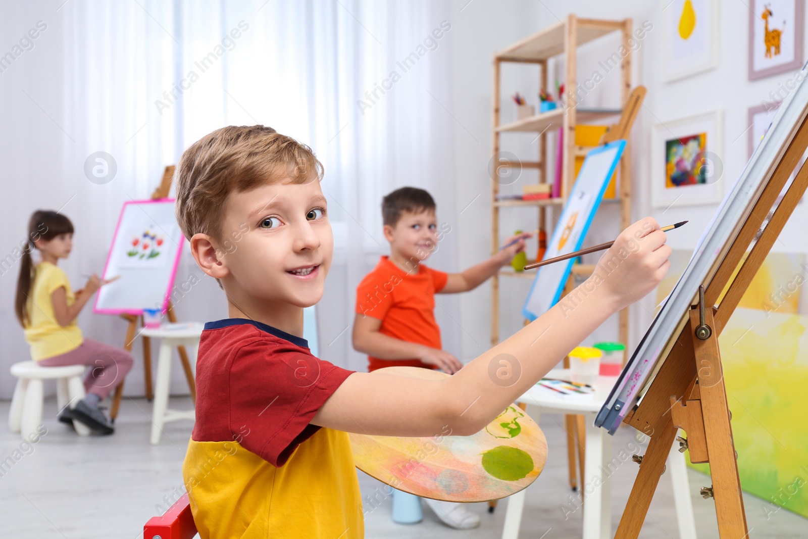 Photo of Cute little children painting during lesson in room