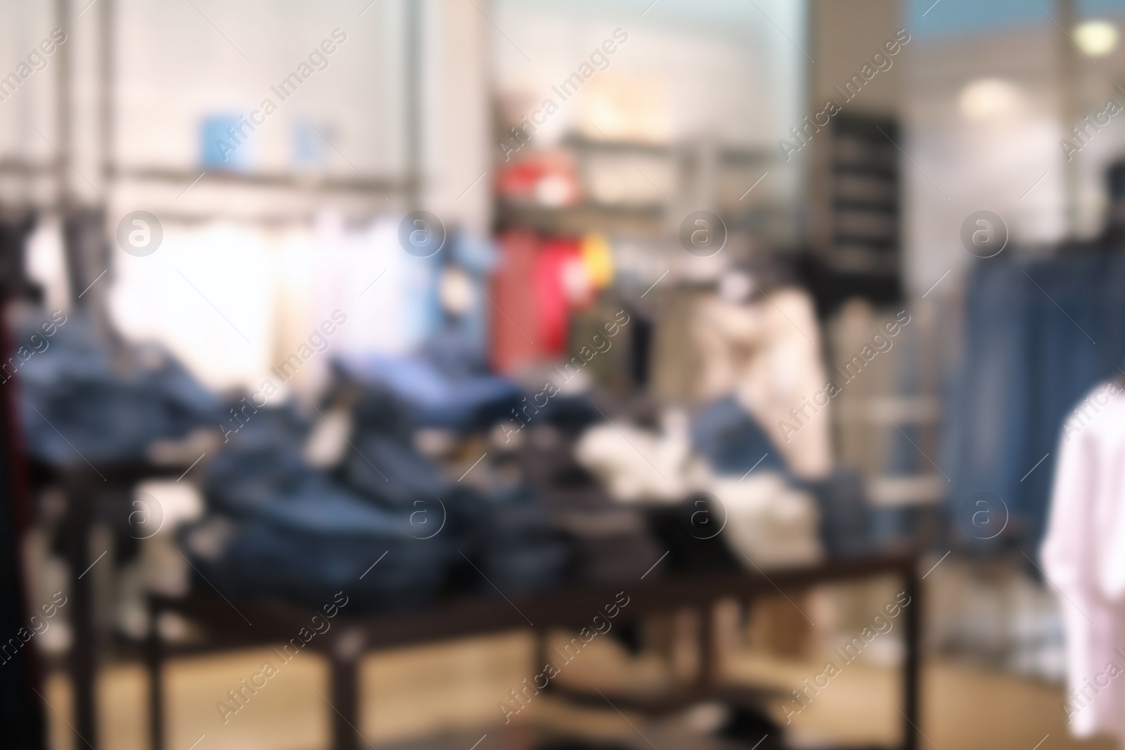 Photo of Blurred view of modern store with different clothes