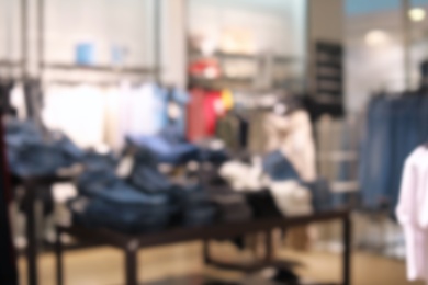 Photo of Blurred view of modern store with different clothes