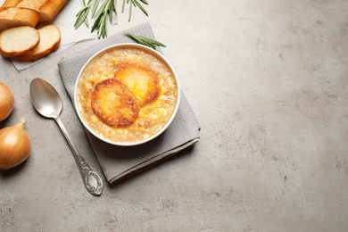 Photo of Tasty homemade french onion soup served on grey table, flat lay. Space for text