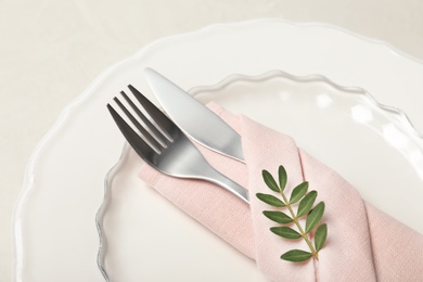 Plate, cutlery and napkin on light background, closeup