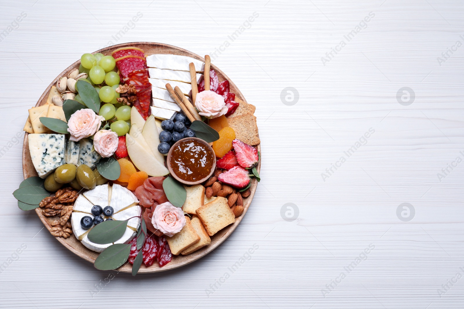 Photo of Assorted appetizer served on white wooden table, top view. Space for text