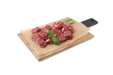 Photo of Wooden board with cut fresh beef meat and basil leaves isolated on white