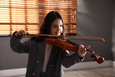 Photo of Preteen girl playing violin in studio at music lesson