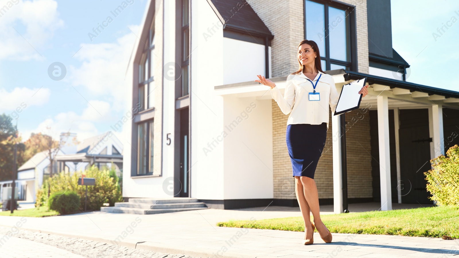 Photo of Real estate agent showing house for sale outdoors