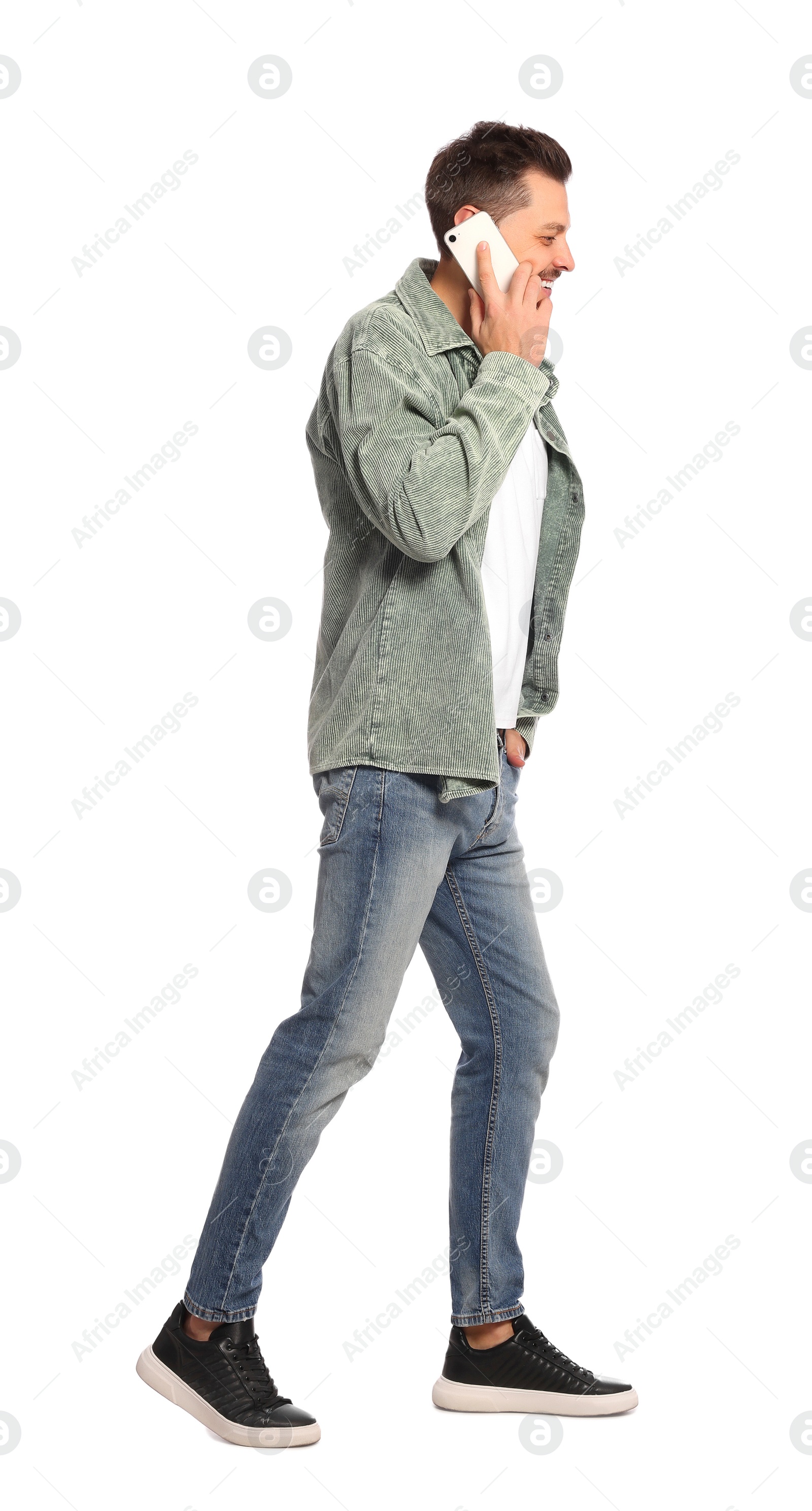 Photo of Man talking on phone while walking against white background