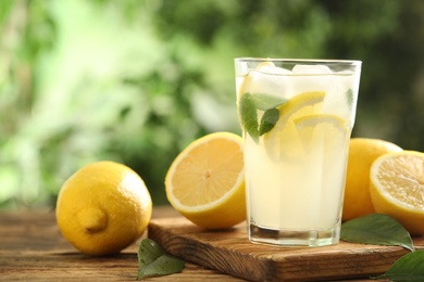 Cool freshly made lemonade and fruits on wooden table. Space for text