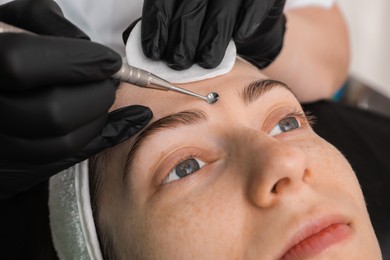 Photo of Cosmetologist using scrubber, closeup. Client having cleansing procedure