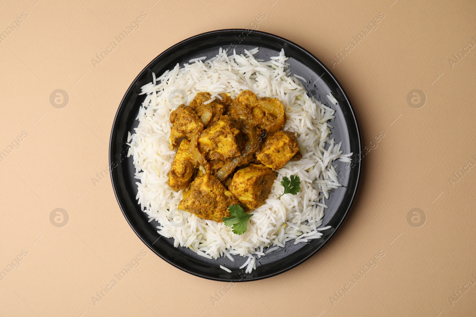 Photo of Delicious chicken curry with rice on beige background, top view