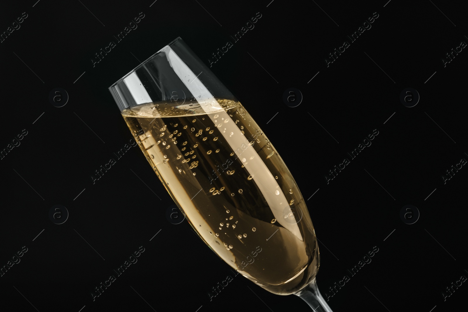 Photo of Glass of sparkling wine on black background
