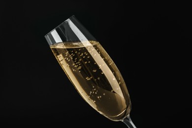 Glass of sparkling wine on black background