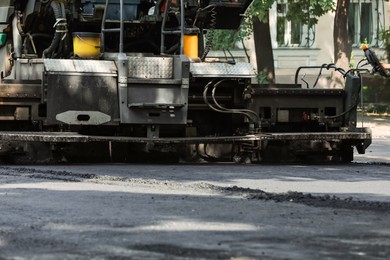 Photo of Modern asphalt finisher on city street. Road repair service