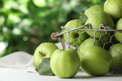Ripe green apples on white table outdoors, closeup. Space for text