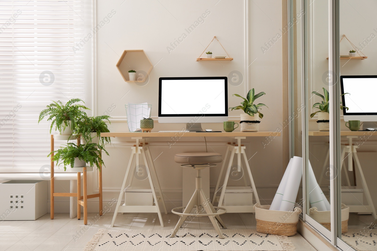 Photo of Comfortable workplace with modern computer and houseplants in room. Interior design