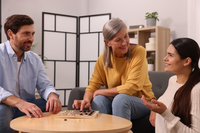 Family playing checkers at coffee table in room