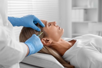 Photo of Trichologist giving injection to patient in clinic, closeup