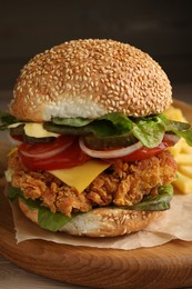 Photo of Delicious burger with crispy chicken patty on wooden table, closeup