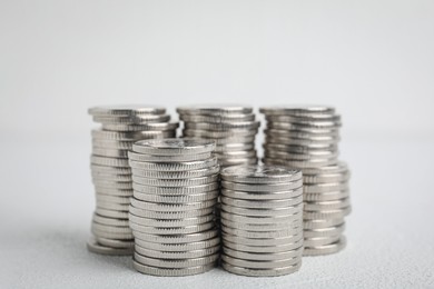 Photo of Many silver coins stacked on white table
