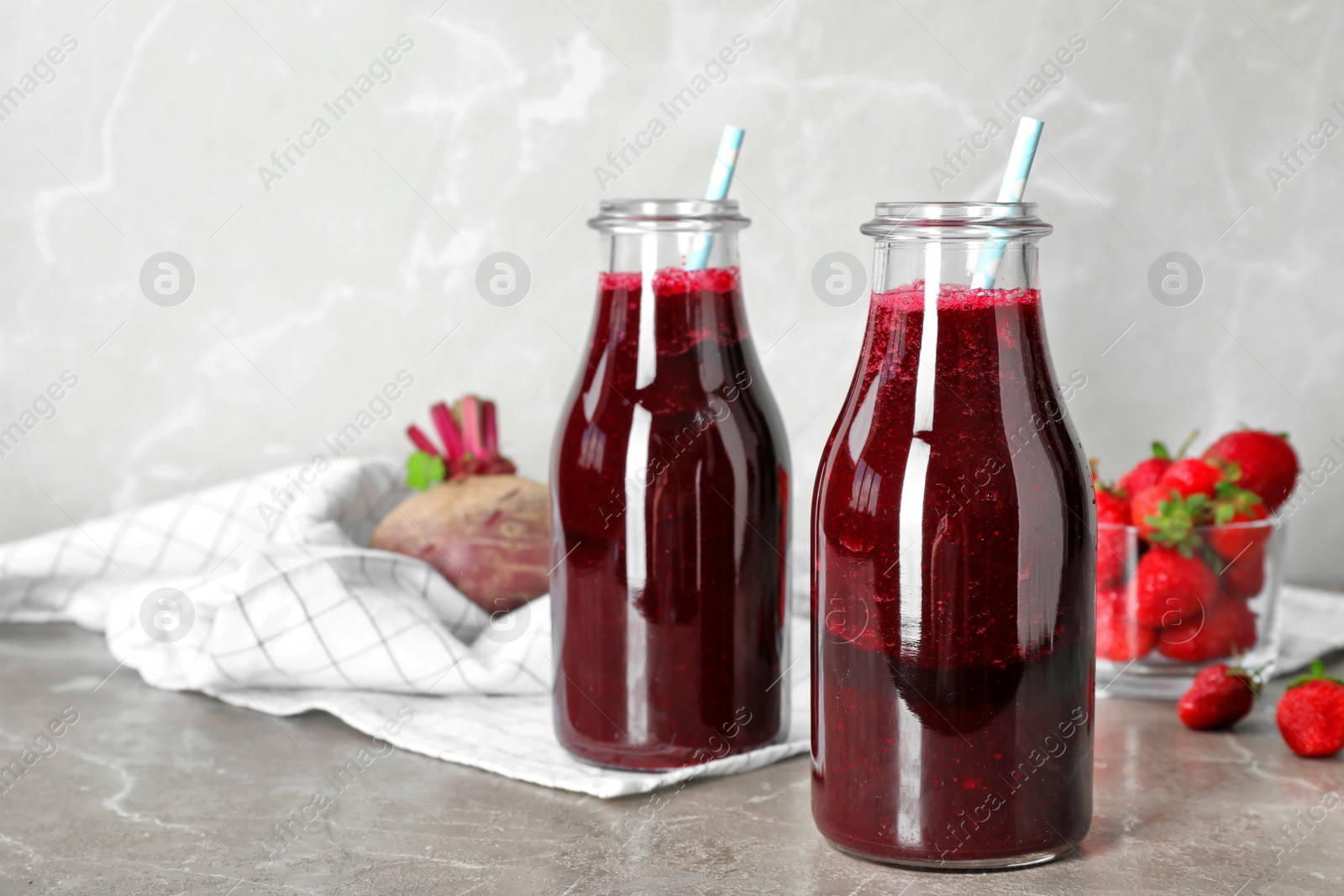 Photo of Bottles with fresh beet juice on table