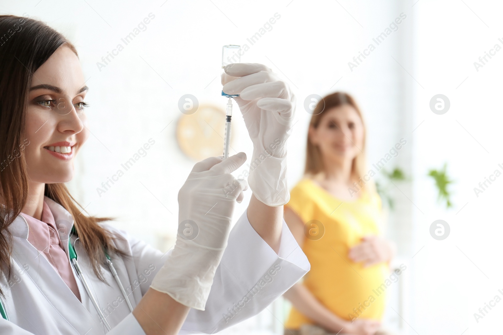 Photo of Doctor holding ampule with vaccine and syringe for patient in clinic