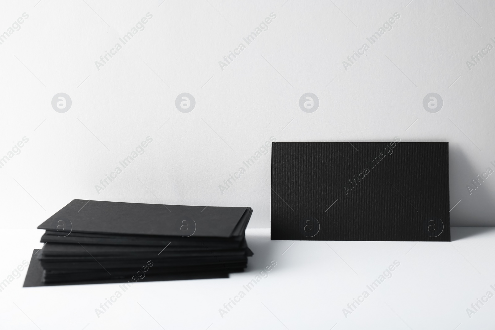 Photo of Blank black business cards on white background. Mockup for design