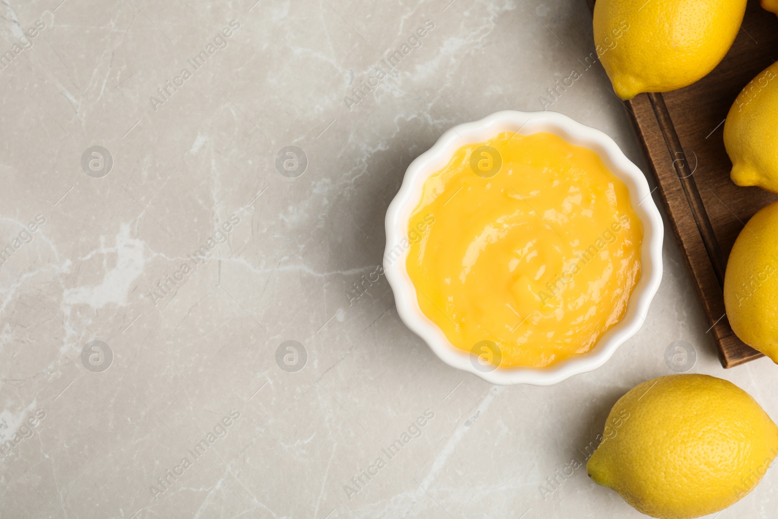 Photo of Delicious lemon curd and fresh fruits on light grey marble table, flat lay. Space for text