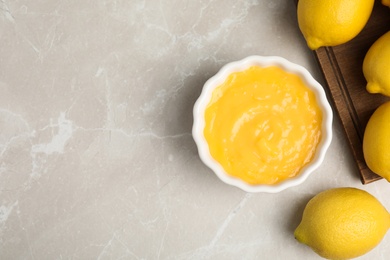 Photo of Delicious lemon curd and fresh fruits on light grey marble table, flat lay. Space for text