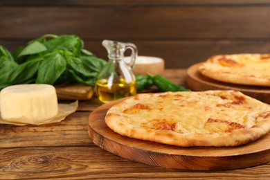 Delicious khachapuri with cheese and basil on wooden table