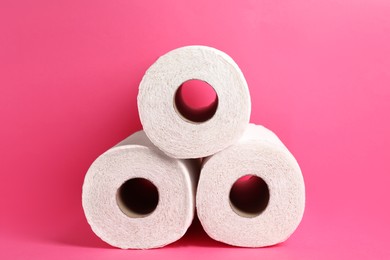Photo of Many rolls of paper towels on pink background