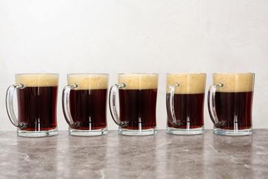 Row of glass mugs with beer on table