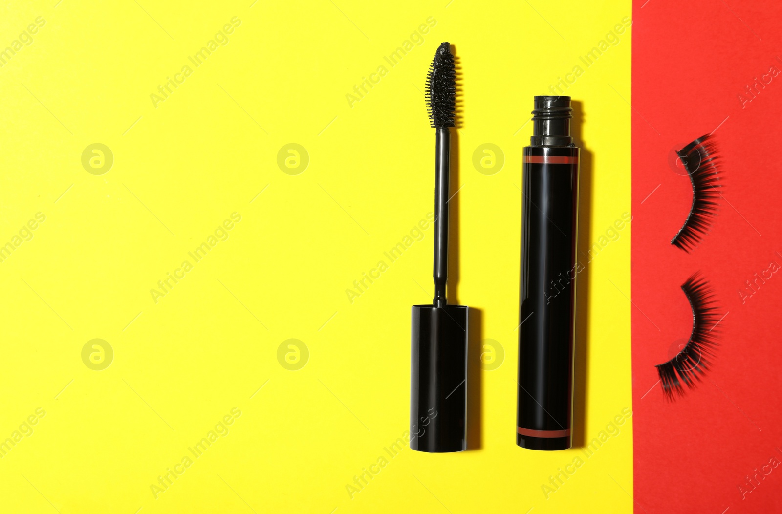 Photo of Black mascara and fake eyelashes on color background, flat lay with space for text. Makeup product