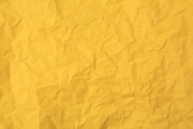 Photo of Sheet of crumpled orange paper as background, top view