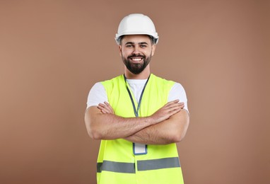 Photo of Engineer with hard hat and badge on brown background