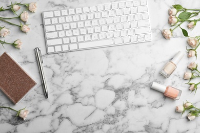 Flat lay composition with beautiful roses and keyboard on marble background. Space for text