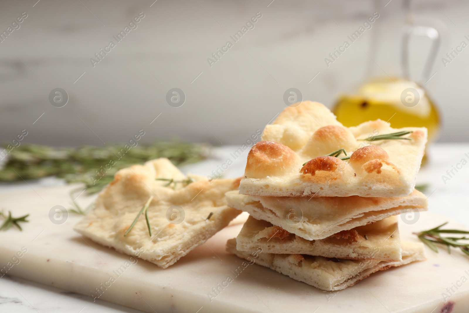 Photo of Delicious focaccia bread on white marble table, closeup