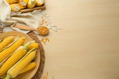 Photo of Tasty fresh corn cobs on wooden table, flat lay. Space for text