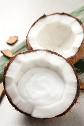 Ripe coconut with cream on light grey table