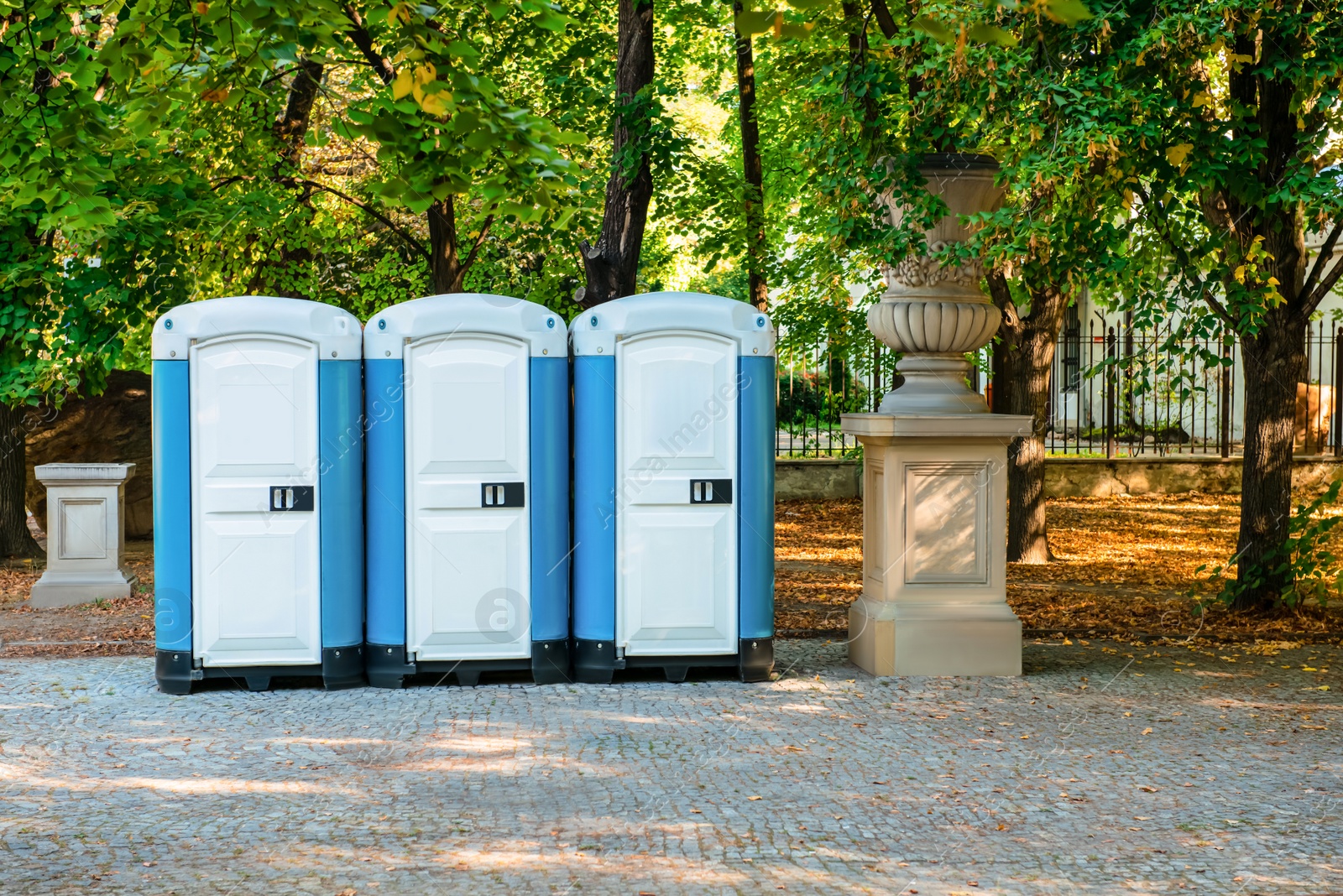 Photo of Public toilet cabins on street near trees