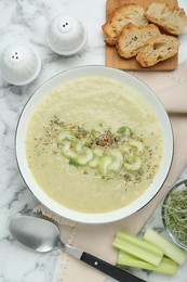 Photo of Delicious celery soup served on white marble table, flat lay