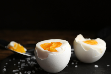 Photo of Tasty boiled chicken eggs on black slate plate, closeup. Space for text