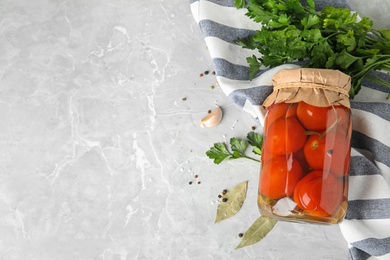 Photo of Flat lay composition with pickled tomatoes in glass jar on grey table, space for text