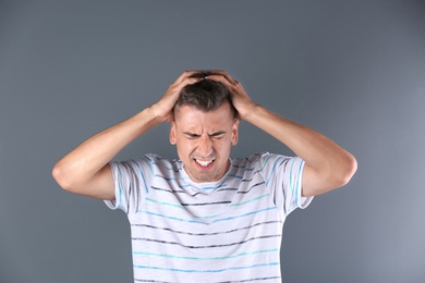 Photo of Handsome emotional young man on color background