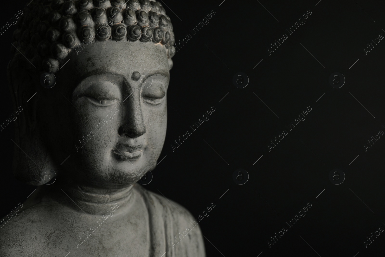 Photo of Beautiful stone Buddha sculpture on black background, closeup. Space for text