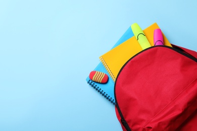 Photo of Flat lay composition with backpack, school stationery and space for text on color background