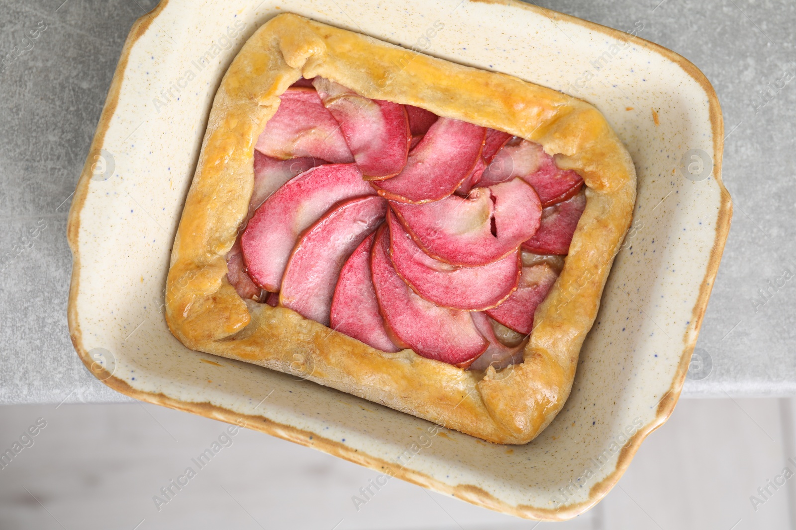 Photo of Tasty galette with apples on light grey table, top view