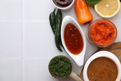 Photo of Different marinades and products on white tiled table, flat lay. Space for text