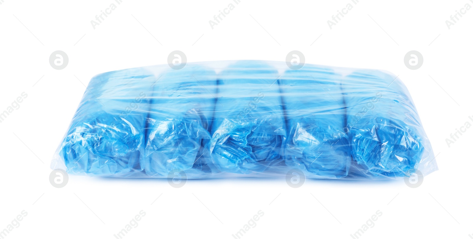 Photo of Package with medical blue shoe covers on white background